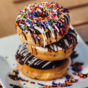 Photo of three sprinkled donuts, stacked on eachother